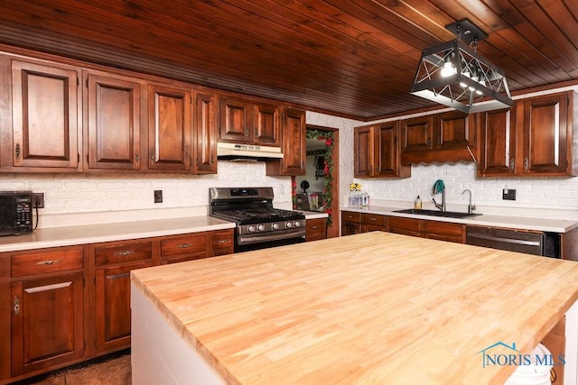 kitchen featuring butcher block counters, sink, pendant lighting, and appliances with stainless steel finishes