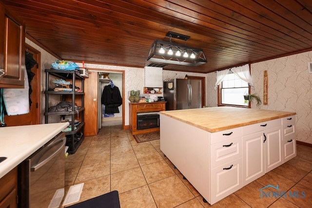 kitchen with pendant lighting, butcher block countertops, white cabinetry, stainless steel appliances, and wood ceiling