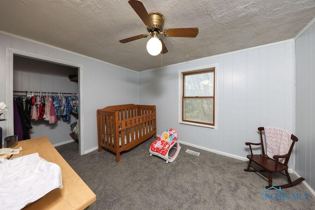 bedroom with ceiling fan, a closet, a textured ceiling, and dark colored carpet