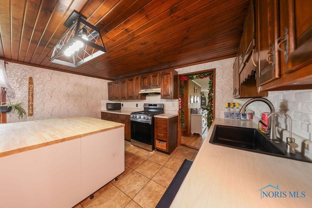 kitchen featuring pendant lighting, wooden ceiling, sink, gas range, and light tile patterned floors