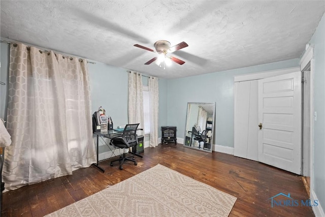 office featuring ceiling fan, dark hardwood / wood-style flooring, and a textured ceiling