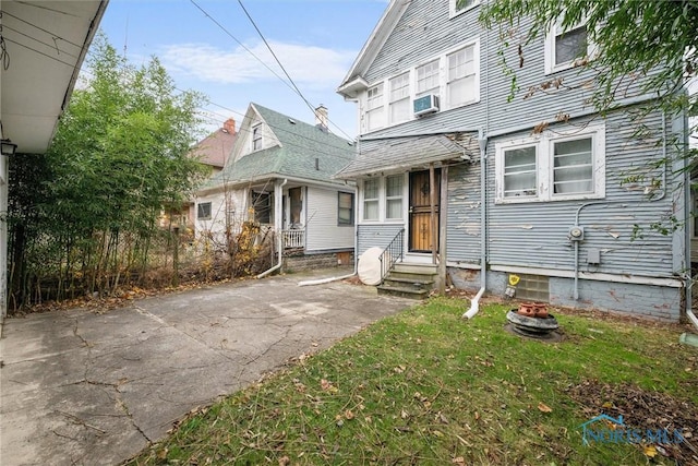 view of front of house with a front yard and cooling unit