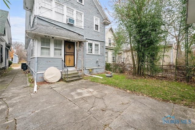 view of front of house with a front yard and cooling unit