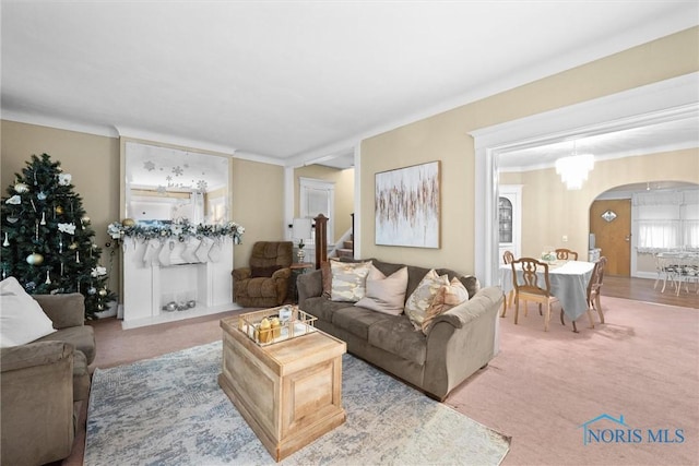 carpeted living room featuring a notable chandelier