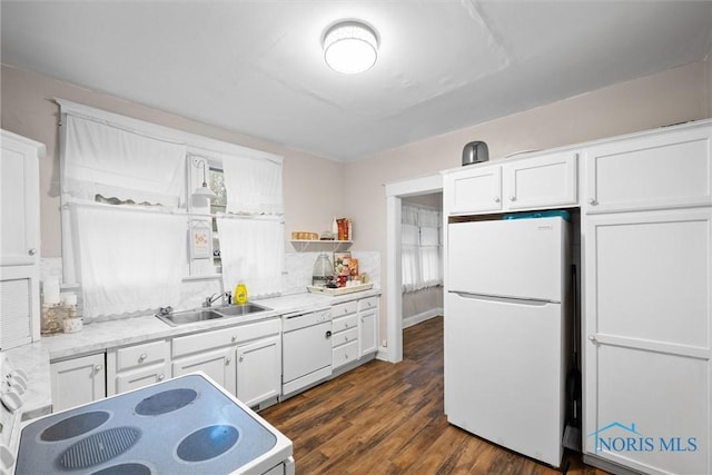 kitchen with white appliances, sink, dark hardwood / wood-style floors, decorative backsplash, and white cabinetry