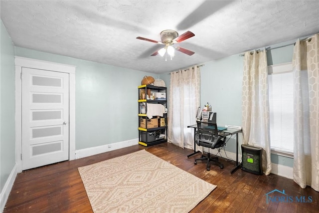 home office featuring ceiling fan, dark hardwood / wood-style flooring, and a textured ceiling