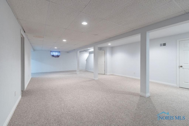 basement featuring carpet flooring and a drop ceiling