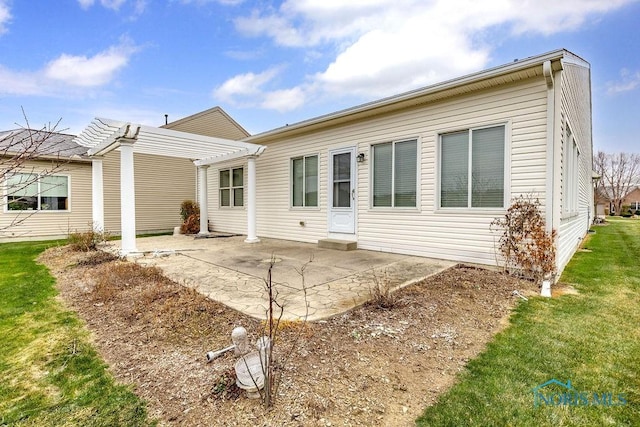 rear view of house featuring a yard, a patio area, and a pergola