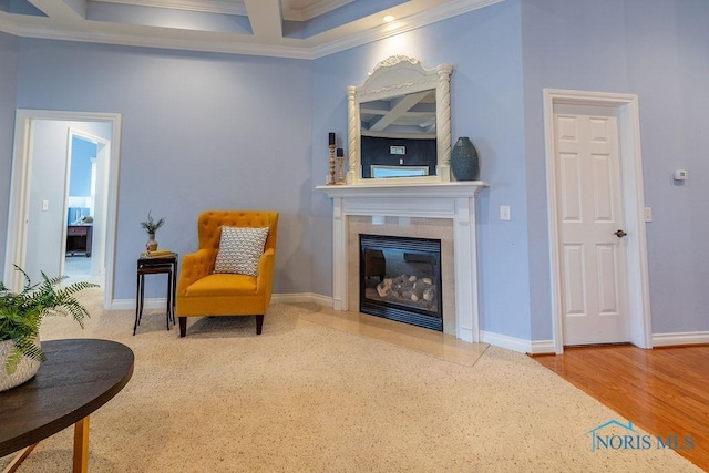 living area featuring beam ceiling, crown molding, coffered ceiling, and a fireplace