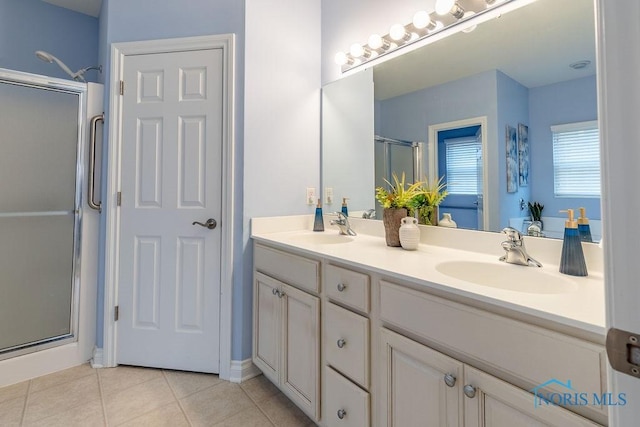 bathroom with tile patterned floors, a shower with door, and vanity