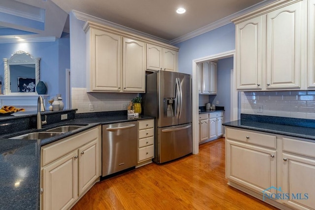 kitchen featuring tasteful backsplash, sink, ornamental molding, light hardwood / wood-style floors, and stainless steel appliances