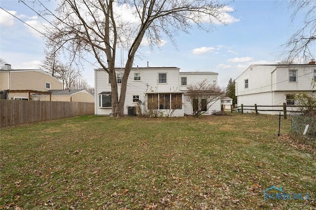 rear view of property featuring a lawn