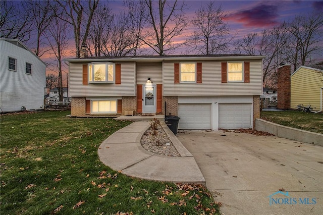 bi-level home with a garage and a yard