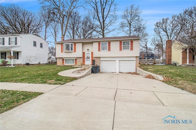 bi-level home featuring a garage and a front lawn