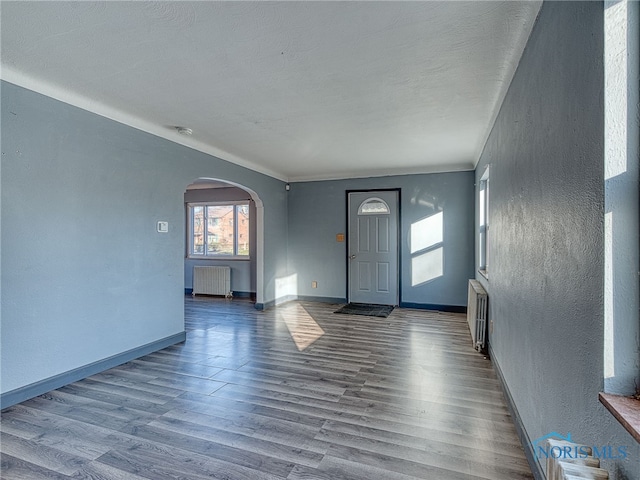 foyer entrance featuring hardwood / wood-style flooring and radiator heating unit