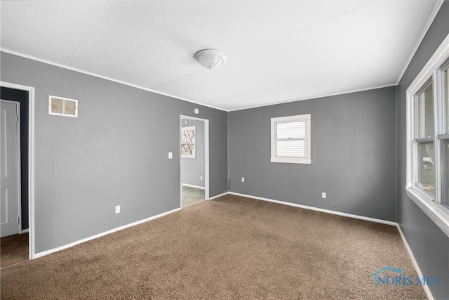 carpeted spare room featuring crown molding