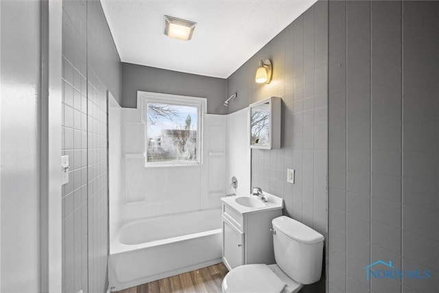 full bathroom with hardwood / wood-style floors, vanity, toilet, and tile walls