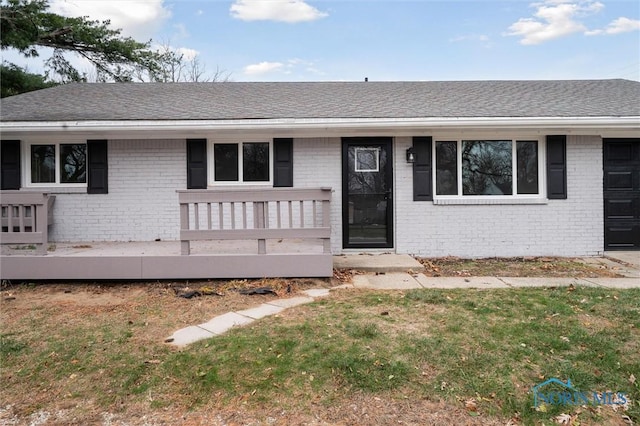 ranch-style house featuring a porch and a front yard