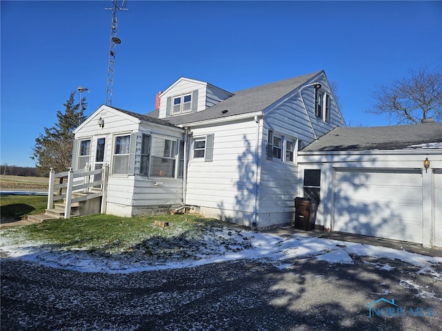 view of home's exterior with a garage and a sunroom