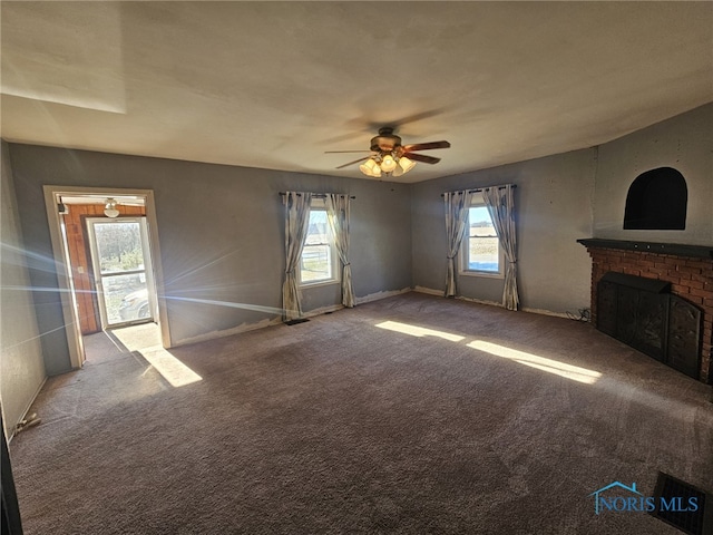 unfurnished living room with a fireplace, carpet floors, and ceiling fan