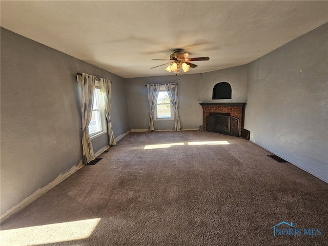 unfurnished living room with carpet flooring, ceiling fan, and a brick fireplace