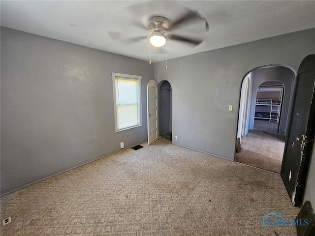 carpeted spare room featuring ceiling fan