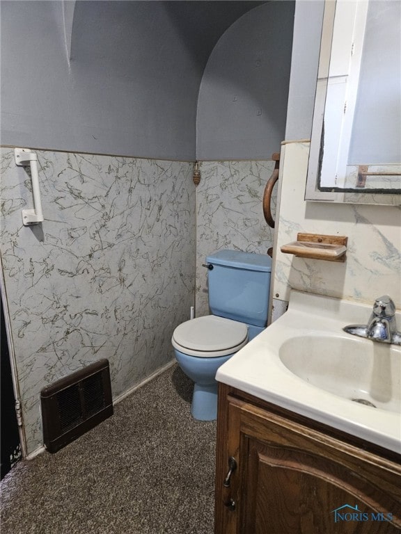 bathroom with vanity, toilet, and tile walls