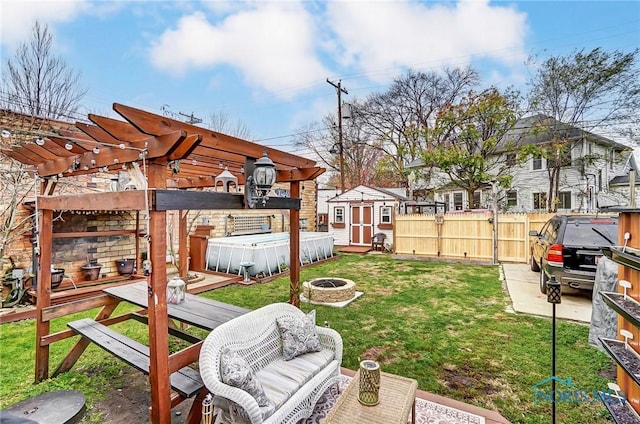 view of yard with a storage unit, a deck, an outdoor fire pit, and a hot tub