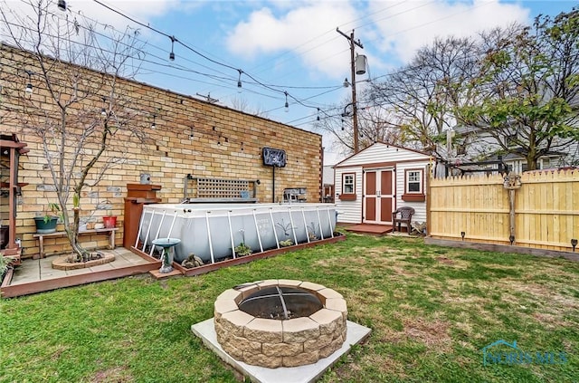 view of yard featuring a storage shed and an outdoor fire pit