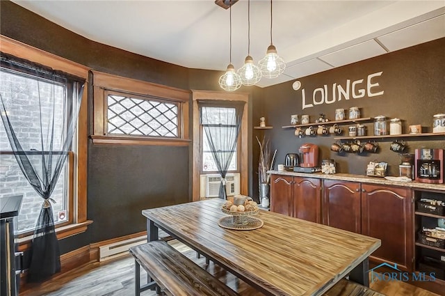 dining space featuring light hardwood / wood-style floors, baseboard heating, and cooling unit