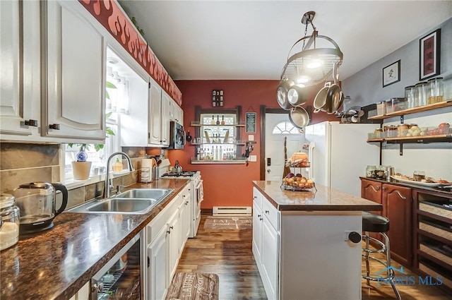 kitchen with a center island, dark wood-type flooring, white cabinets, and stainless steel appliances