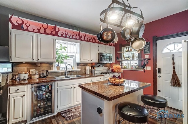 kitchen featuring a center island, white cabinets, dark hardwood / wood-style floors, white range oven, and beverage cooler