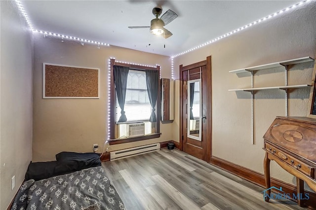 bedroom featuring wood-type flooring, a baseboard radiator, ceiling fan, and cooling unit