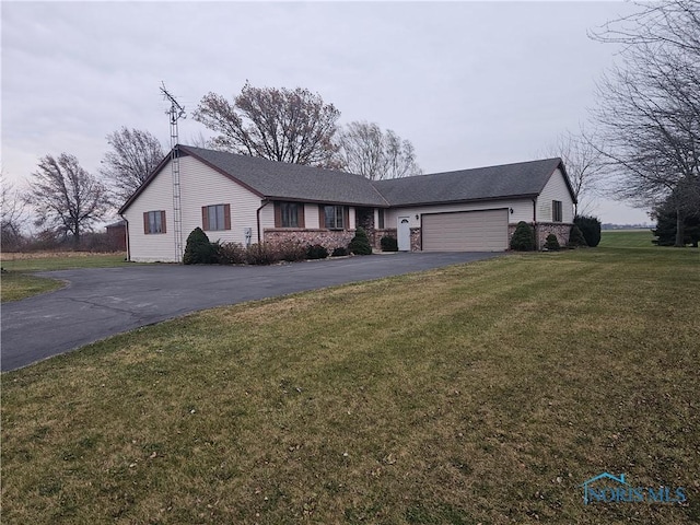 ranch-style house featuring a front lawn and a garage