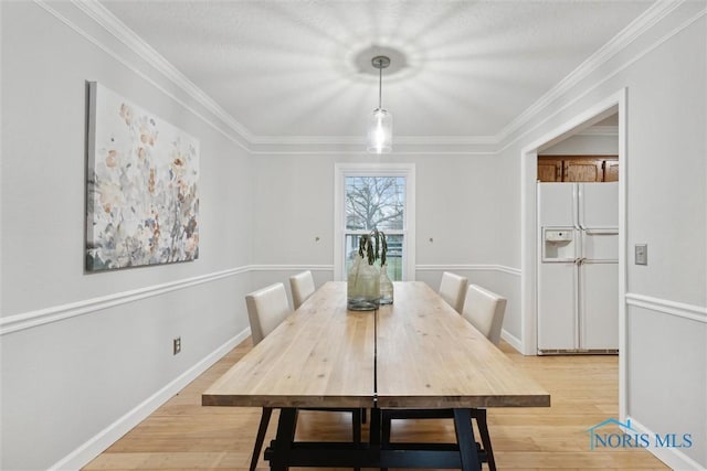 dining space with light hardwood / wood-style flooring and crown molding