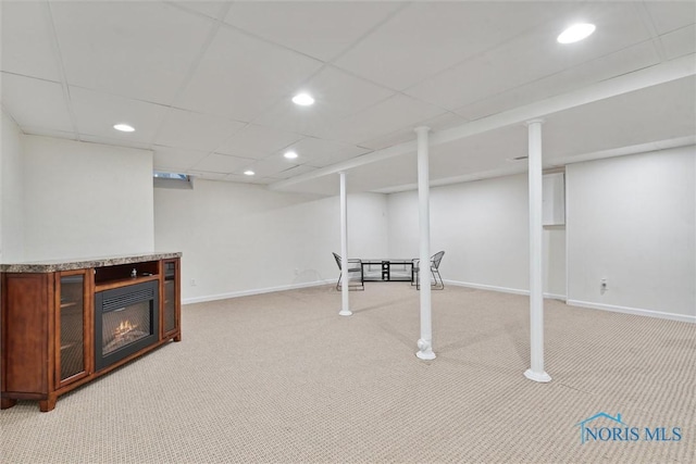 basement with carpet flooring and a paneled ceiling