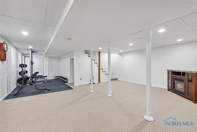 exercise area featuring a paneled ceiling and light carpet