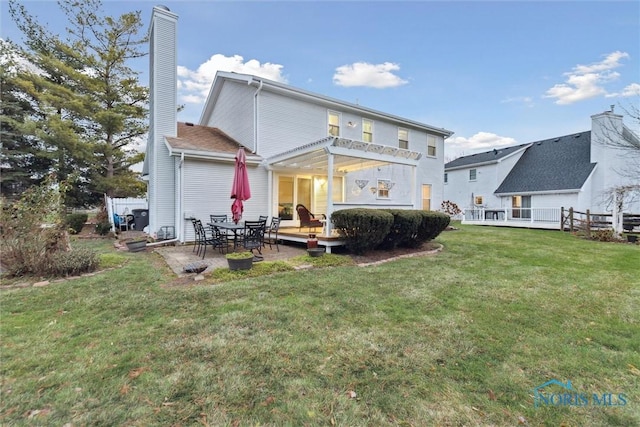 back of property with a yard and a patio