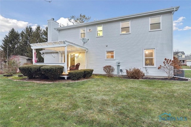 rear view of property with a pergola and a lawn