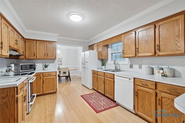 kitchen featuring sink, light hardwood / wood-style flooring, a textured ceiling, white appliances, and ornamental molding