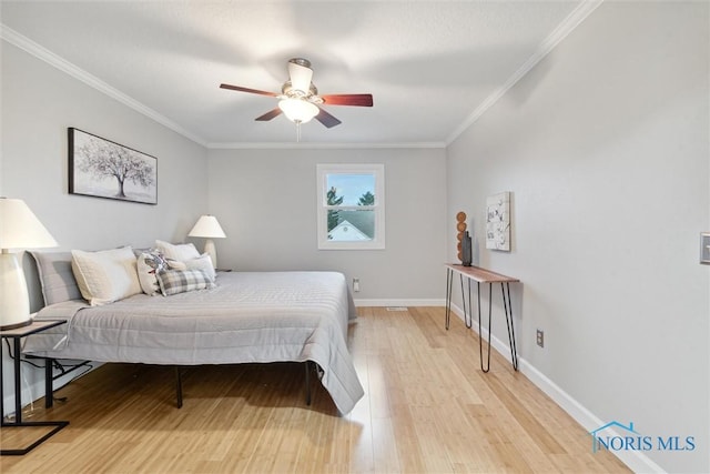 bedroom featuring light hardwood / wood-style floors, ceiling fan, and ornamental molding