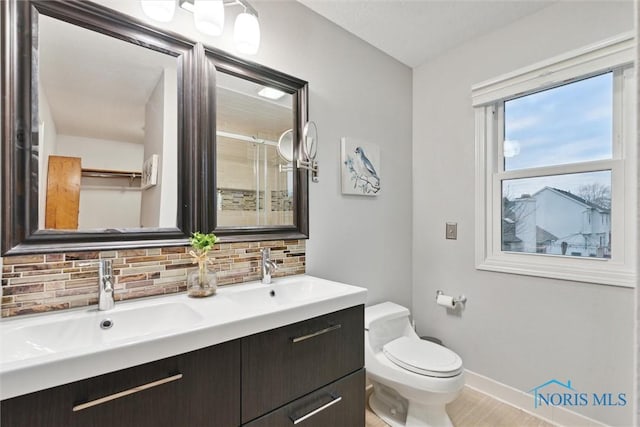 bathroom featuring decorative backsplash, vanity, wood-type flooring, and toilet