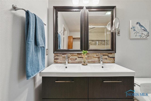 bathroom with decorative backsplash, vanity, and toilet