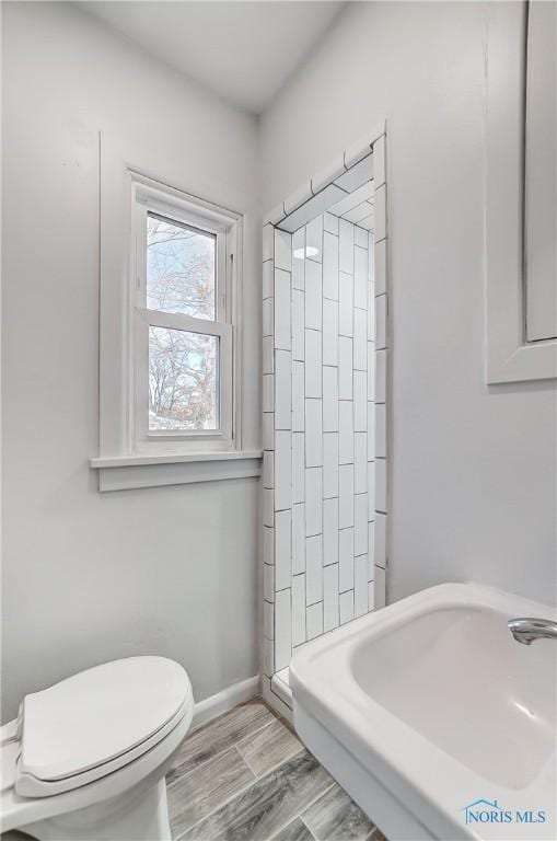 bathroom featuring a shower, wood-type flooring, and toilet