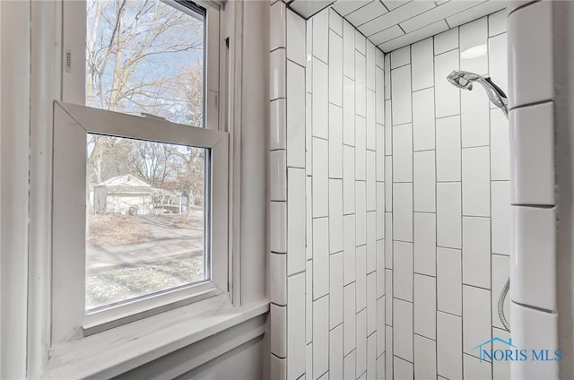 interior details featuring tiled shower