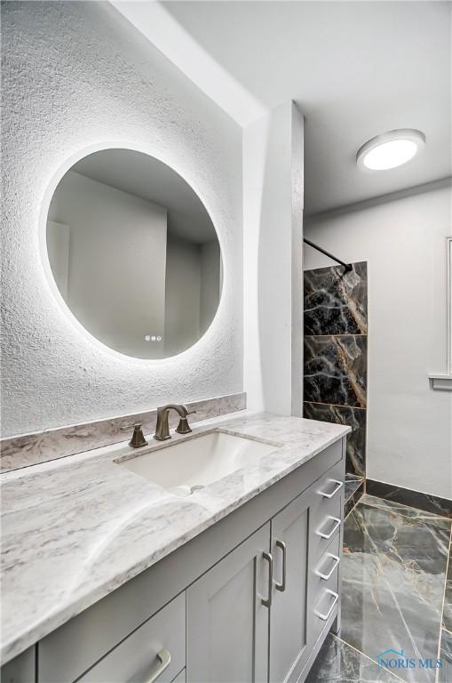 bathroom with a shower and vanity