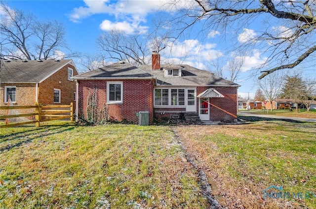 back of property featuring a lawn and central AC