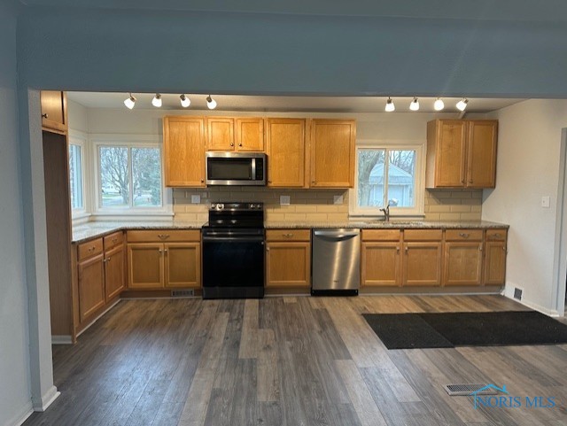 kitchen featuring decorative backsplash, dark hardwood / wood-style flooring, sink, and appliances with stainless steel finishes