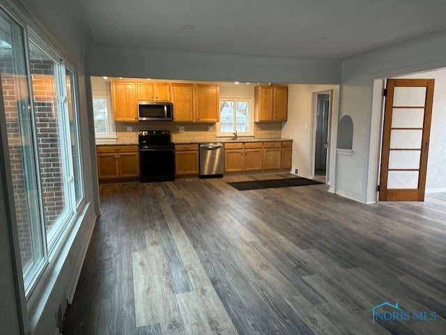 kitchen with backsplash, sink, stainless steel appliances, and dark hardwood / wood-style floors