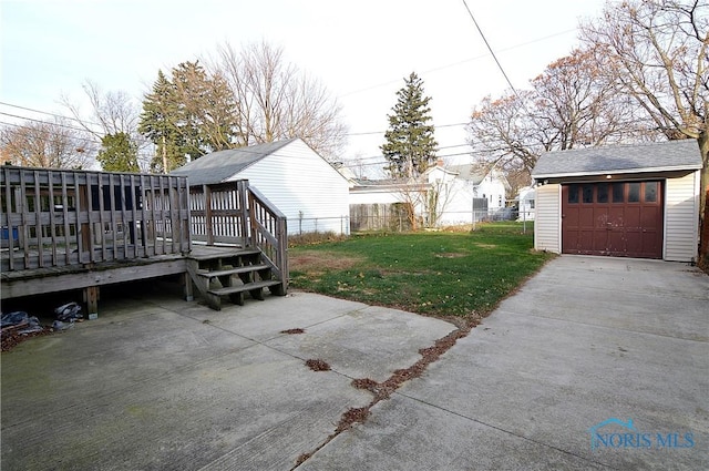 view of yard with a deck, a garage, and an outdoor structure